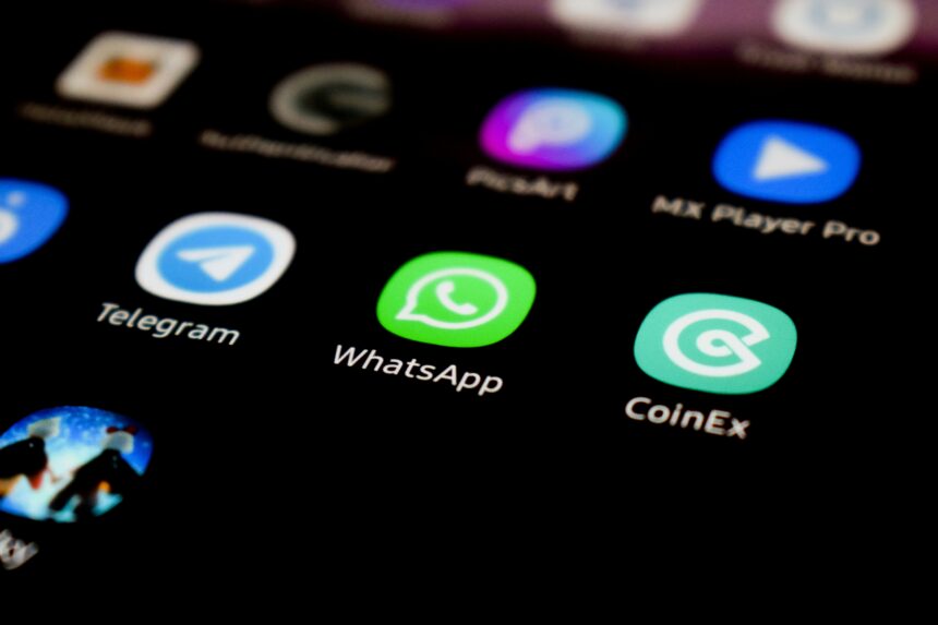 WhatsApp app icon on a smartphone screen alongside Telegram and other apps.